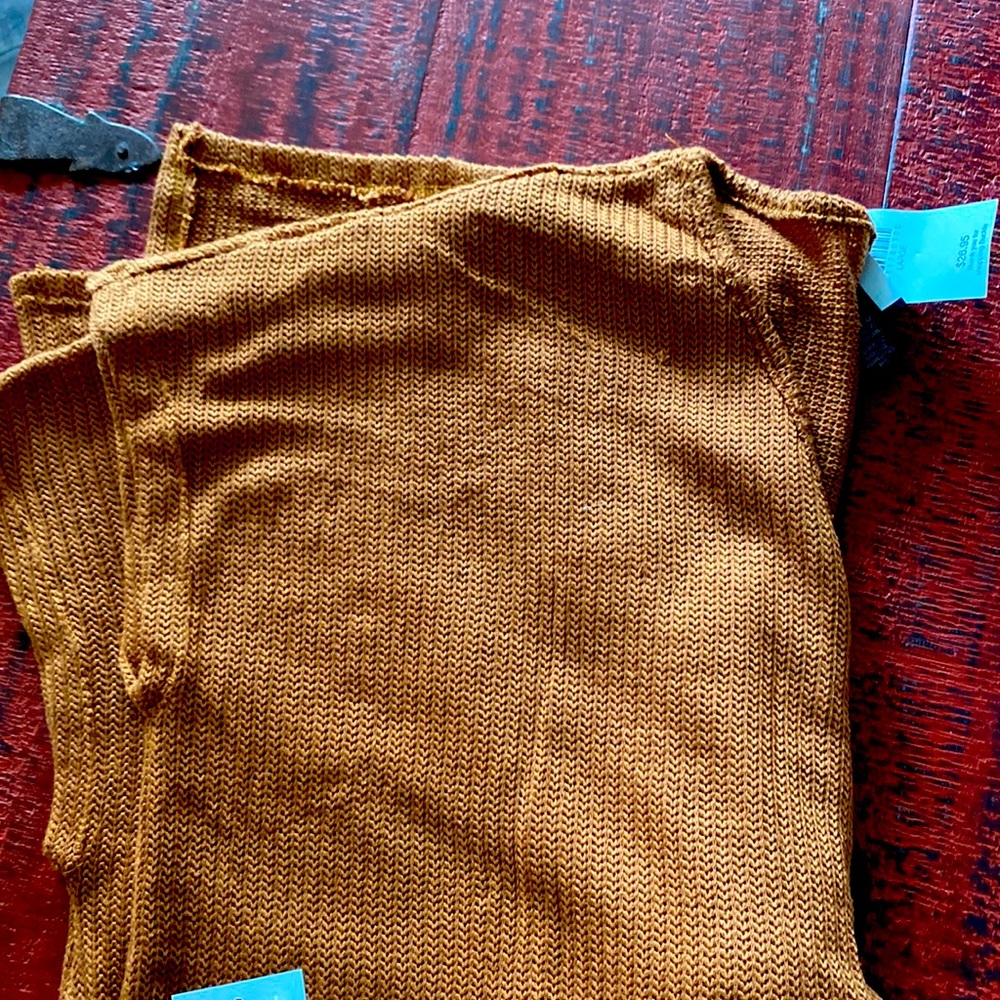 Golden brown knit shirt. Never worn. Ties in front and longer in the back.